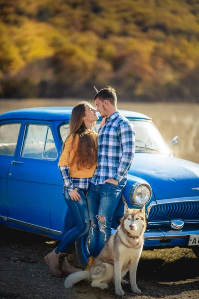 Par Kärlek Och Husky Hund Poserar Nära Blå Bil — Stockfoto