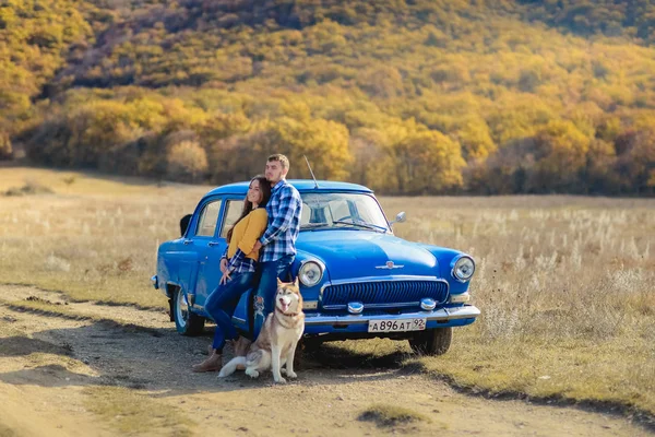 Par Kärlek Och Husky Hund Poserar Nära Blå Bil — Stockfoto