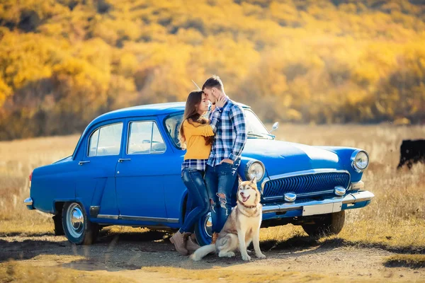 愛とハスキー犬の青い車に近いポーズのカップル — ストック写真