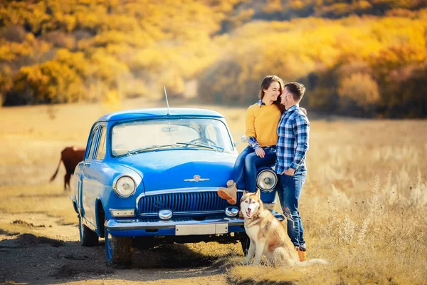愛とハスキー犬の青い車に近いポーズのカップル — ストック写真