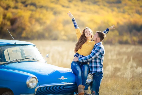 青い車に近いポーズの愛の若いカップル — ストック写真