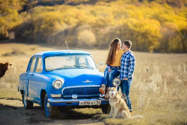 愛とハスキー犬の青い車に近いポーズのカップル — ストック写真