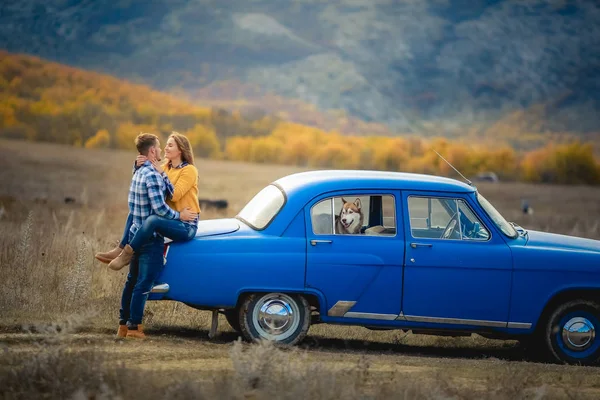 iki sevgi ve husky köpek mavi arabanın yakınında poz sonra 