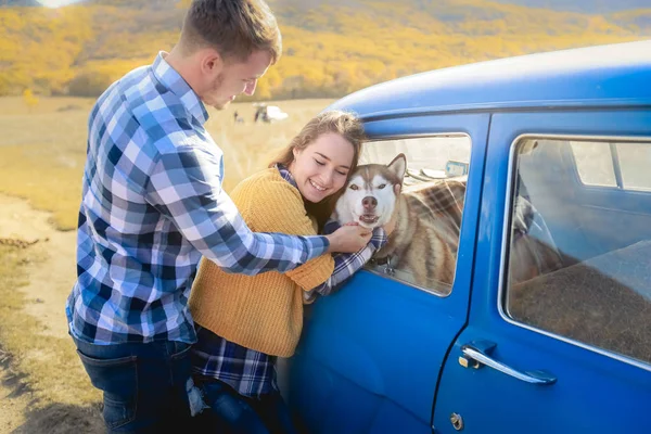 Cuplu Dragoste Câine Husky Care Pozează Lângă Mașina Albastră — Fotografie de stoc gratuită