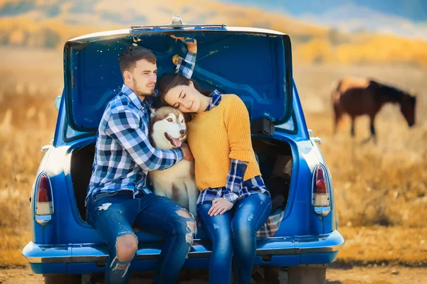 Άνδρας Και Γυναίκα Που Ποζάρει Σκυλιά Husky Στη Μπλε Αυτοκίνητο — Φωτογραφία Αρχείου
