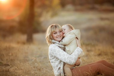 Anne ve kızı günbatımında sonbahar bahçede poz 