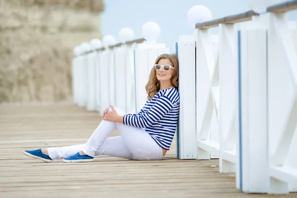 海の近くの橋でポーズ美しい陽気な女性 — ストック写真