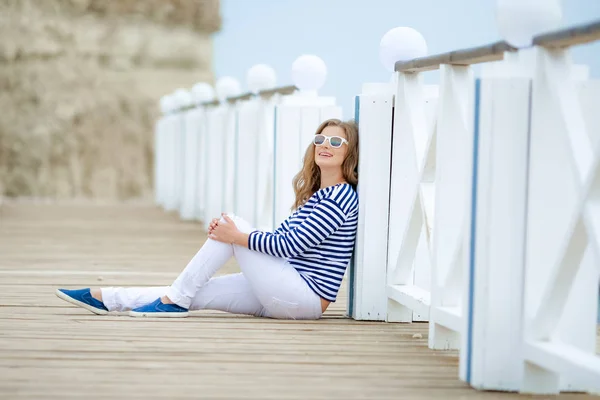 海の近くの橋でポーズ美しい陽気な女性 — ストック写真