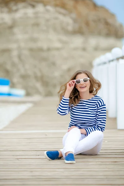 海の近くの橋でポーズ美しい陽気な女性 — ストック写真