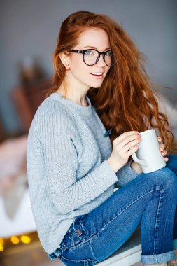 güzel genç kırmızı saçlı kadın kupa ile poz 