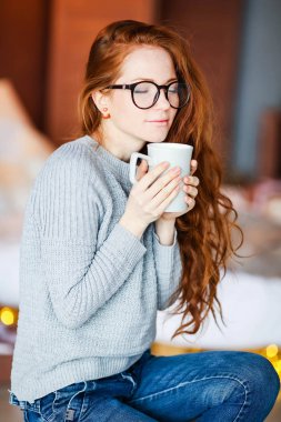 güzel genç kırmızı saçlı kadın kupa ile poz 