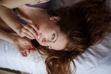 güzel kırmızı saçlı kadın yatakta yatan portresi kapatın 