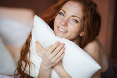 güzel kırmızı saçlı kadın yatak odasında poz 