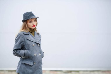 Açık Gri şapka ve paltosunu giyen güzel sarışın kadın portresi 