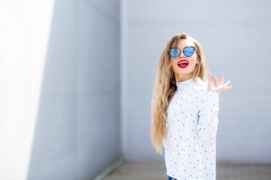 Genç güzel sarışın kadın açık havada rahat kıyafetlerle poz 