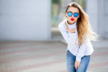 Genç güzel sarışın kadın açık havada rahat kıyafetlerle poz 