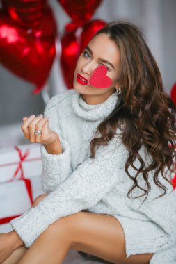 arka plan üzerinde kalp şeklinde balonlar ile stüdyoda poz kadın. Sevgililer günü kavramı 