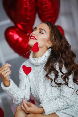 arka plan üzerinde kalp şeklinde balonlar ile stüdyoda poz kadın. Sevgililer günü kavramı 