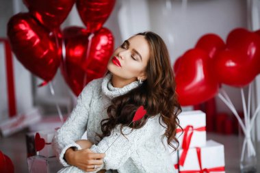 arka plan üzerinde kalp şeklinde balonlar ile stüdyoda poz kadın. Sevgililer günü kavramı 