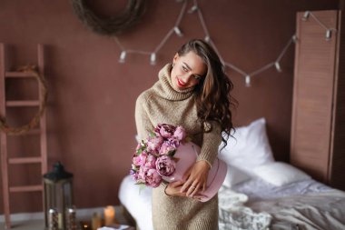 güzel esmer kız mor çiçekler buket tutan Studio'da poz 