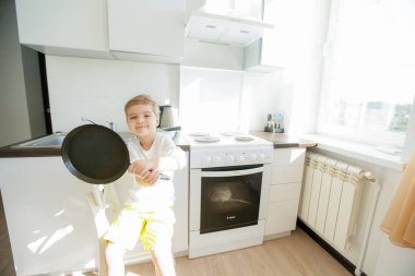 Mutfak mutfak aletleri ile poz şirin küçük çocuğa 