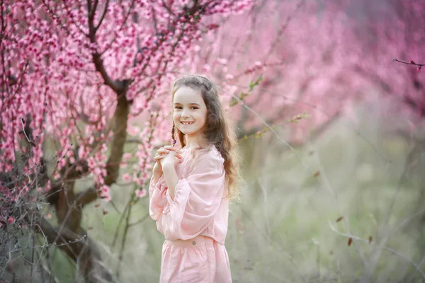 Krásná Holčička Pózuje Venku Zahradě Proti Kvetoucí Stromy — Stock fotografie