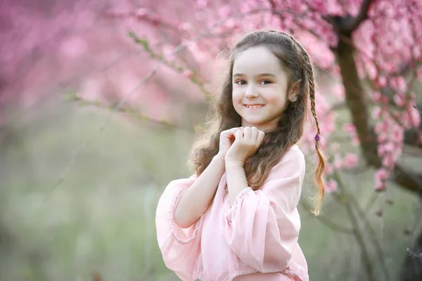 Krásná Holčička Pózuje Venku Zahradě Proti Kvetoucí Stromy — Stock fotografie