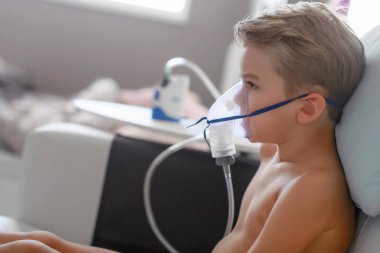 Child taking respiratory, inhalation therapy at home  clipart