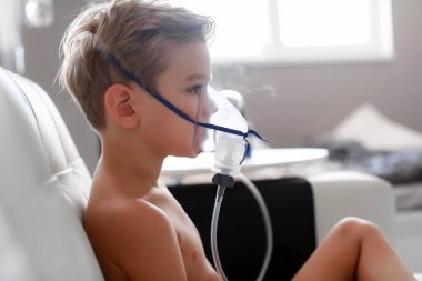 Child taking respiratory, inhalation therapy at home  clipart