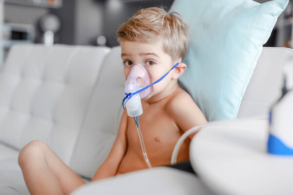 Child taking respiratory, inhalation therapy at home 