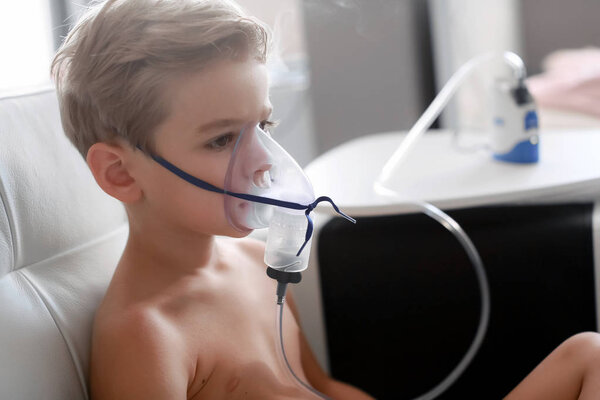 Child taking respiratory, inhalation therapy at home 
