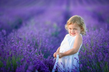 Lavanta alan holding sepet üzerinde çiçek dolu poz güzel küçük kız