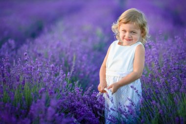 Lavanta alan holding sepet üzerinde çiçek dolu poz güzel küçük kız