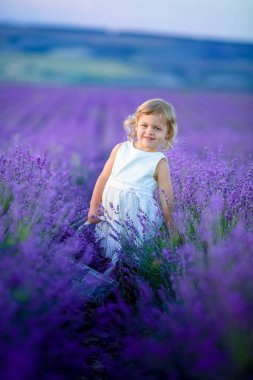 Lavanta alan holding sepet üzerinde çiçek dolu poz güzel küçük kız