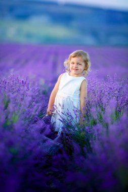 Lavanta alan holding sepet üzerinde çiçek dolu poz güzel küçük kız