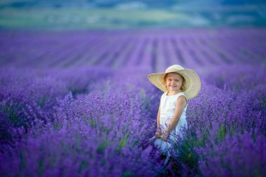 Lavanta alan holding sepet üzerinde çiçek dolu poz güzel küçük kız