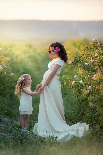 フィールドでポーズの娘と妊娠中の母親 — ストック写真