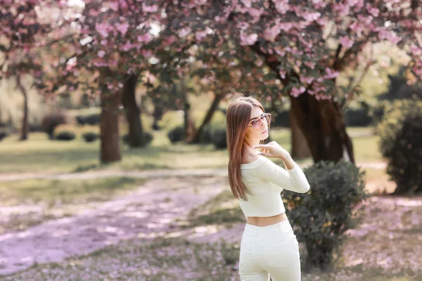 Молодая Красивая Женщина Позирует Против Цветущих Деревьев — стоковое фото