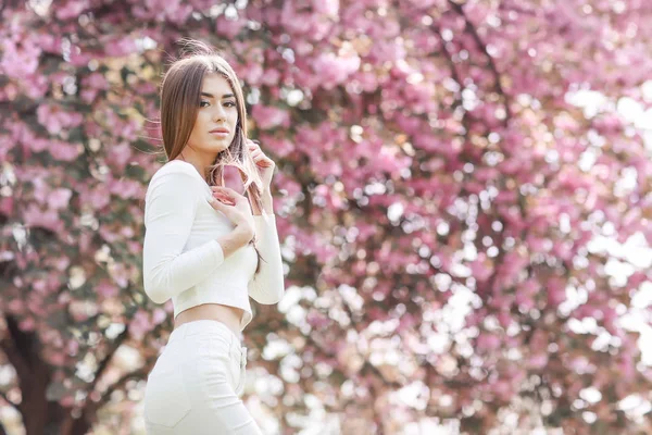 stock image young beautiful woman posing against blooming trees 