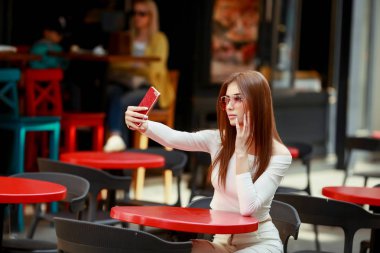 Telefonunuzun ve açık kafede oturan güzel kadın 