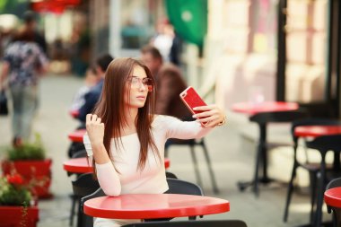 Telefonunuzun ve açık kafede oturan güzel kadın 