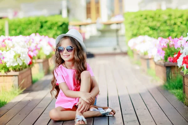 可爱的小女孩摆在户外穿着休闲服装帽子和太阳镜 — 图库照片