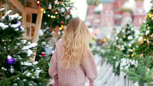 Loira com cabelos longos em um novo dia de inverno de anos no fundo de uma cidade decorada — Vídeo de Stock