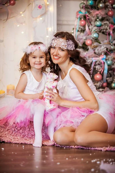 Czarująca matka i córka ubrane w różową, puszystą spódnicę na tle choinki — Zdjęcie stockowe