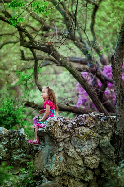 Dívka venku na procházku v lese s kvetoucími šeříky — Stock fotografie
