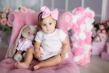 Pembe manzaranın arka planında 1 yıllık bir kız çocuğu. Büyük numaralar 1.