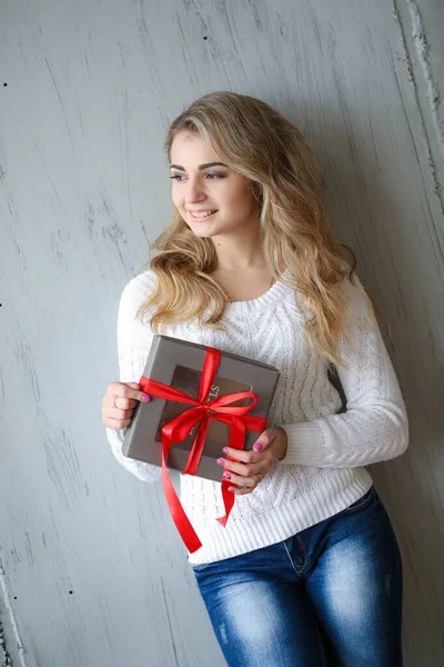 Mulher detém um presente em uma caixa em um aniversário ou ano novo — Fotografia de Stock