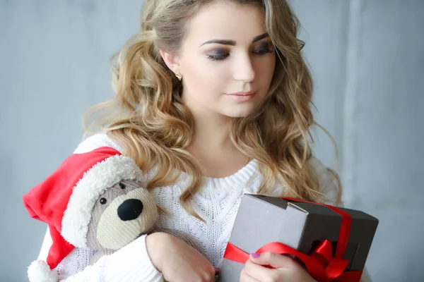Close-up van een vrouw die lacht en een doos vasthoudt met een geschenk en een speelgoedbeer — Stockfoto