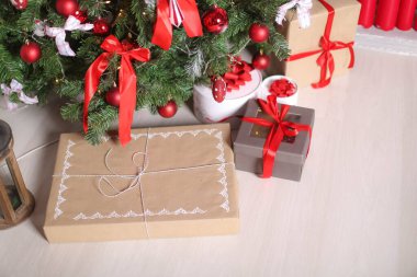 Noel süsleri Noel ağacının yanındaki ambalaj kağıdına konmuş hediye kutuları
