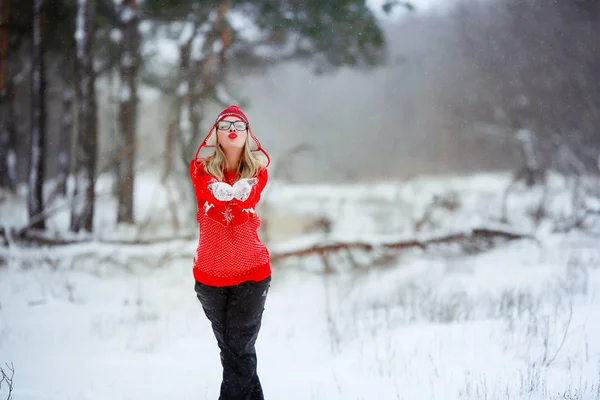 Eine Frau im roten Pullover genießt im Winter das Leben auf einer verschneiten Lichtung — Stockfoto